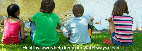 Children in front of lake Children sitting in front of water.